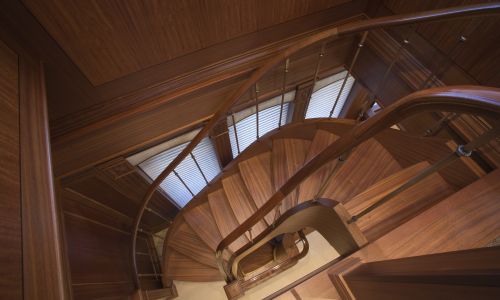Photo of wooden interior stairwell and handrails of yacht