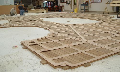 Large teak deck panel with templates lying on top of it
