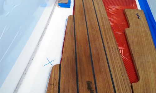 Installation of teak panels with epoxy beneath the panels